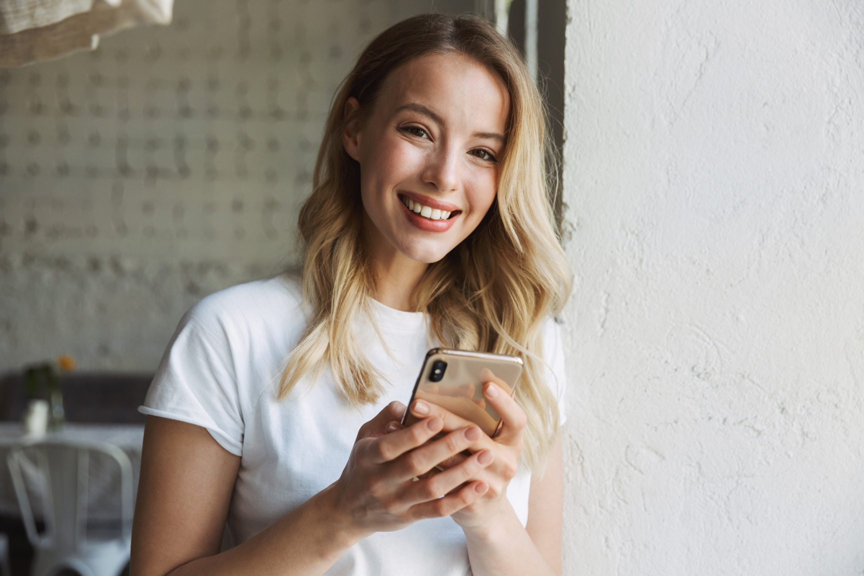 Smiling Woman Uses a Smartphone